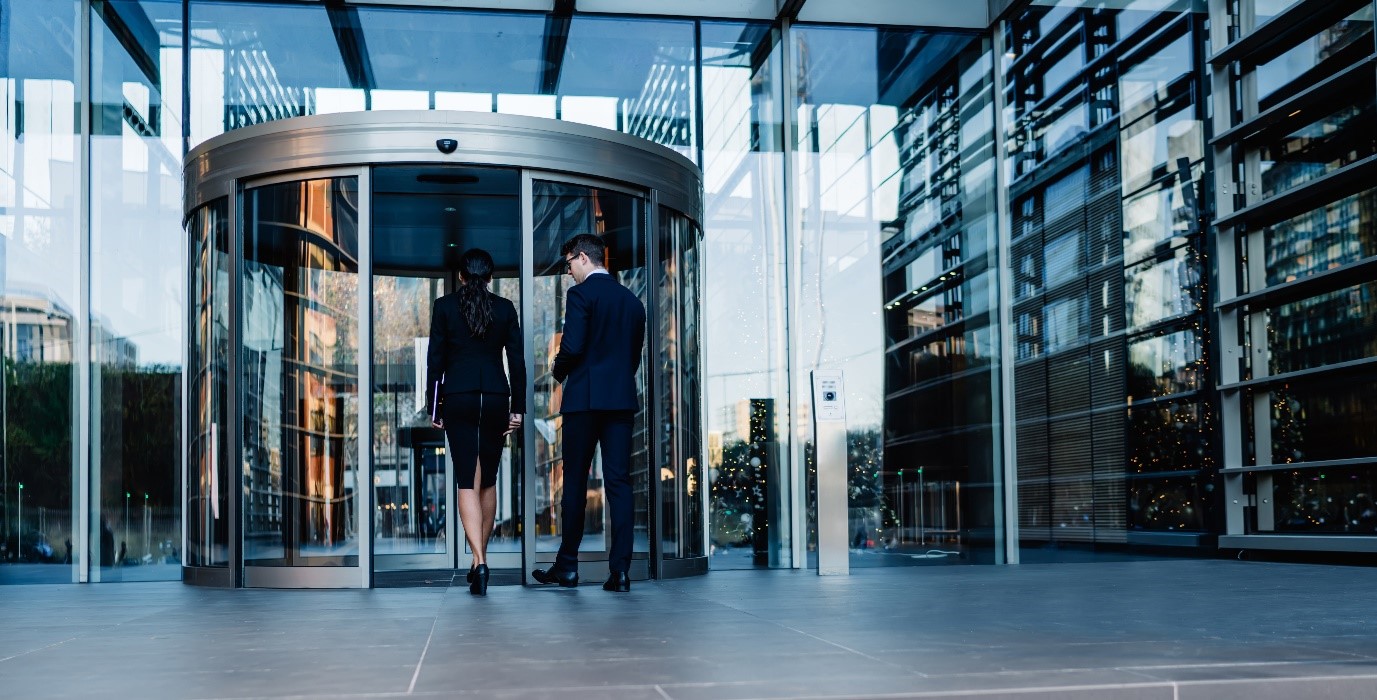 Businesspeople enter a modern financial business protected by access control and CCTV systems